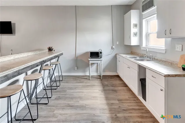 a kitchen with sink cabinets and wooden floor