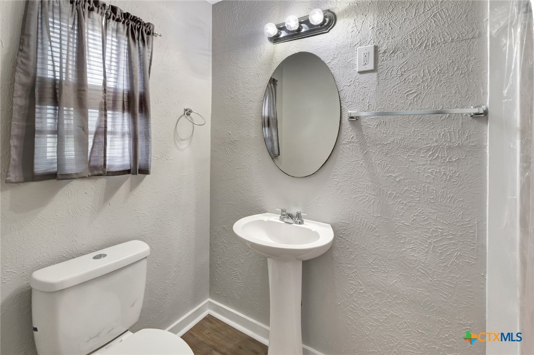 103 5th Street Seadrift, TX 77983 - Photo 5 of 18 a bathroom with a toilet sink and mirror