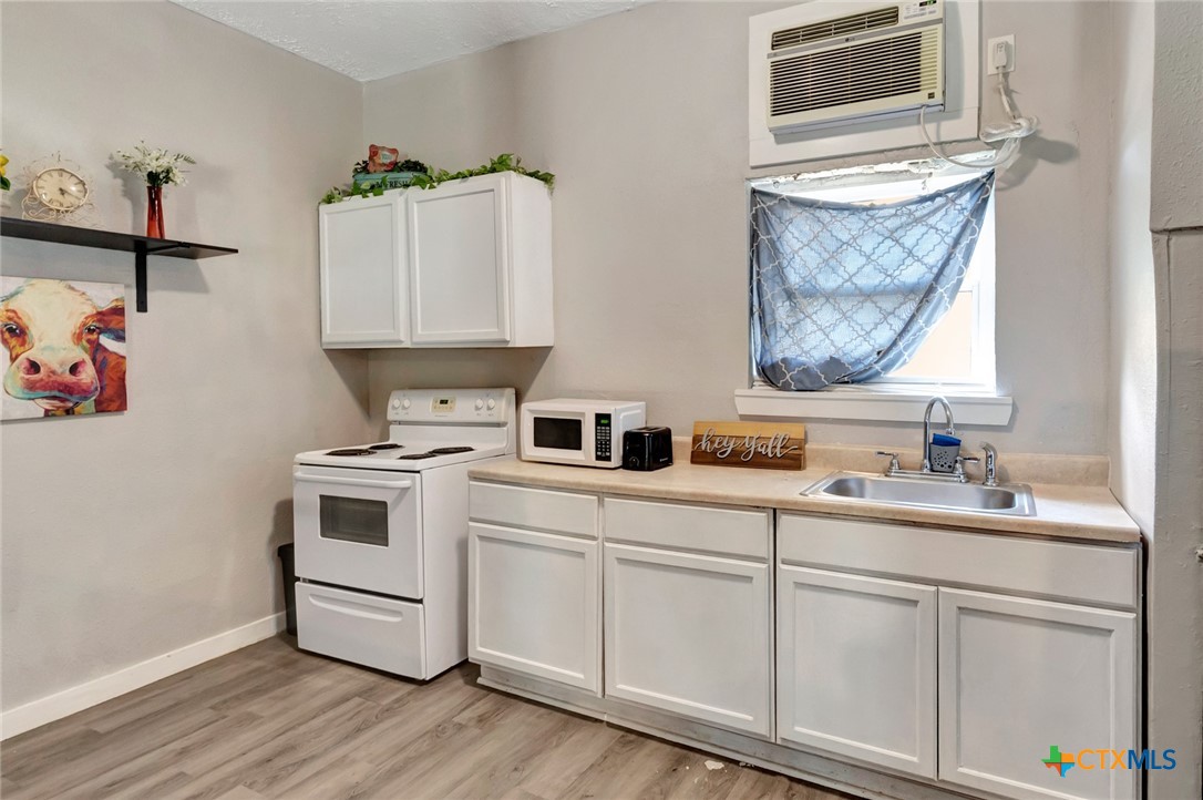 103 5th Street Seadrift, TX 77983 - Photo 6 of 18 a kitchen with sink cabinets and stove
