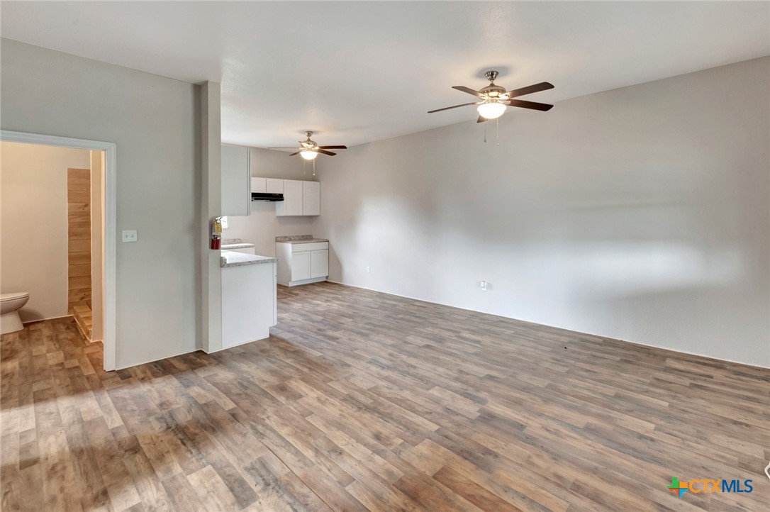 103 5th Street Seadrift, TX 77983 - Photo 9 of 18 a view of a room with wooden floor and a ceiling fan