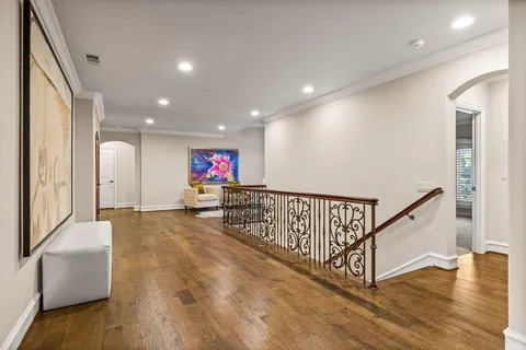 a view of a hallway with wooden floor and stairs