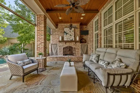 a outdoor space with patio the couches and a fireplace with the potted plants
