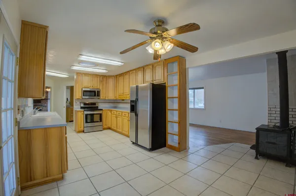 a kitchen with stainless steel appliances kitchen island granite countertop a refrigerator and a stove top oven