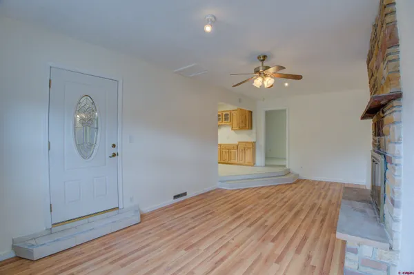a view of an empty room with window and wooden floor