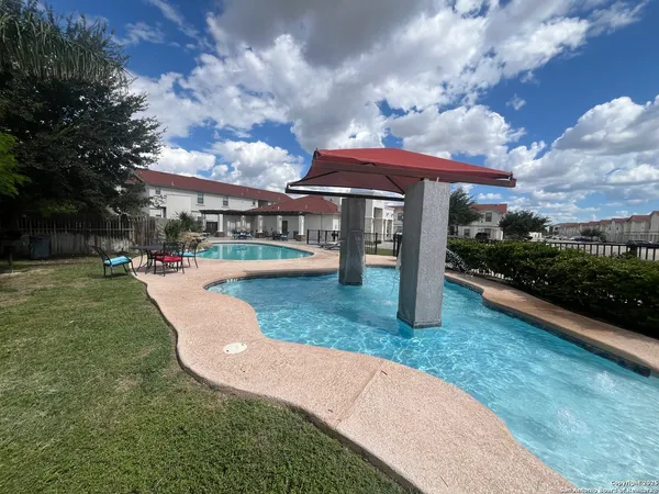 a view of a garden with a table and chairs under an umbrella