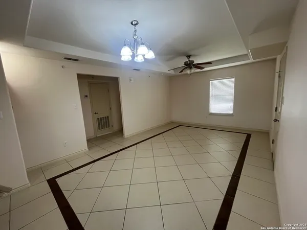 en empty room with wooden floor and chandelier