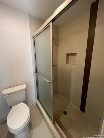 a bathroom with a toilet and a shower