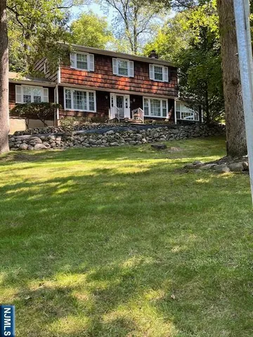 a front view of a house with swimming pool and chairs