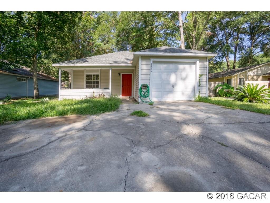 1940 Southwest 73rd Street Gainesville, FL 32607 - Photo 1 of 1 a front view of a house with a yard and a garage