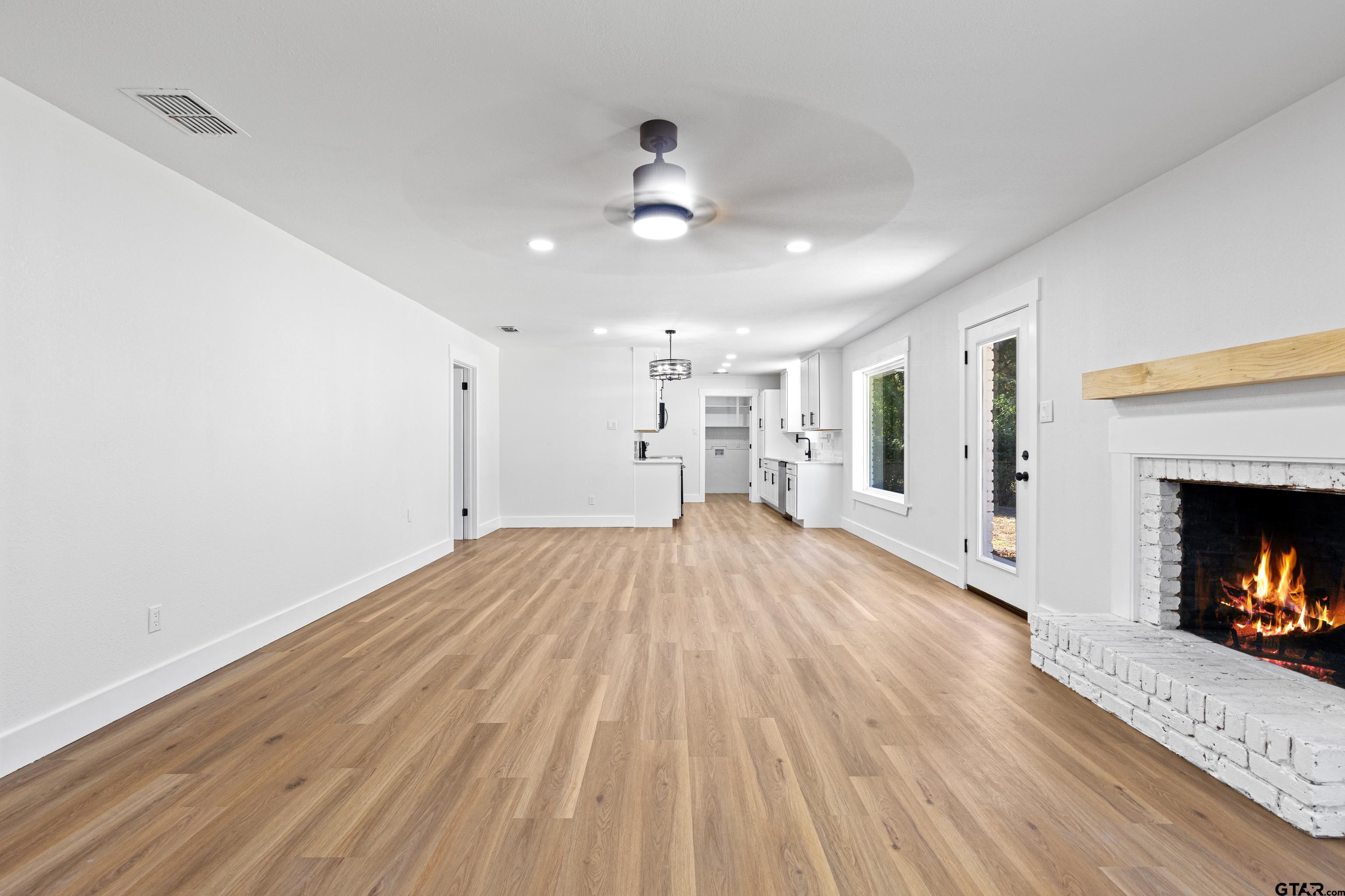 1907 Beth Drive Longview, TX 75605 - Photo 14 of 40 a view of a room with wooden floor a fireplace and window