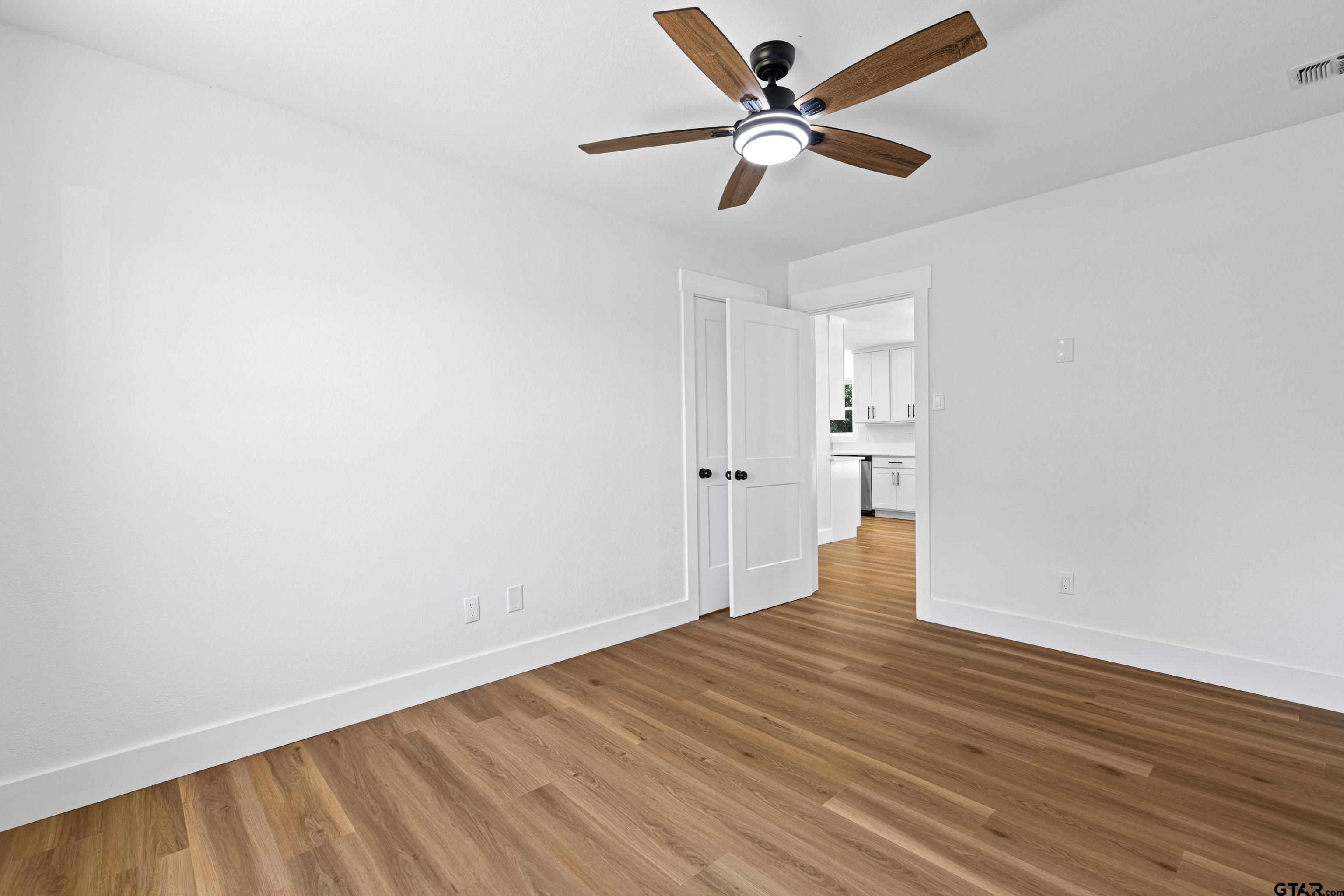 1907 Beth Drive Longview, TX 75605 - Photo 19 of 40 an empty room with wooden floor and a ceiling fan