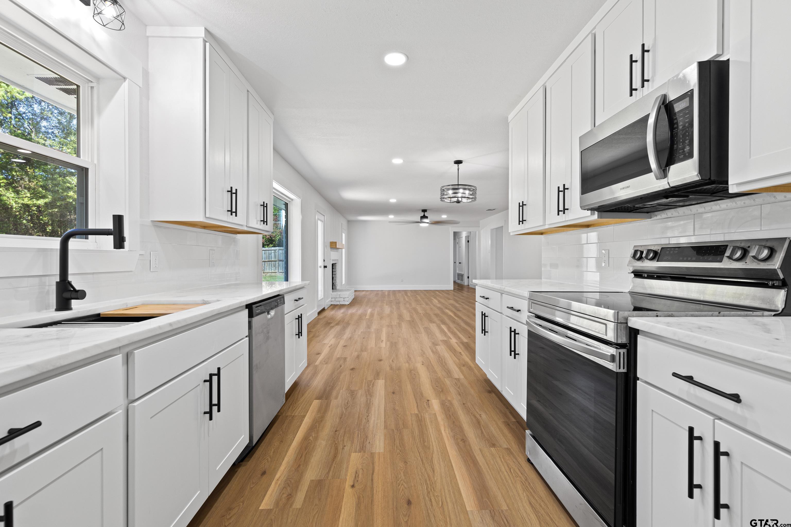 1907 Beth Drive Longview, TX 75605 - Photo 24 of 40 a large kitchen with stainless steel appliances granite countertop a lot of counter space and wooden floors