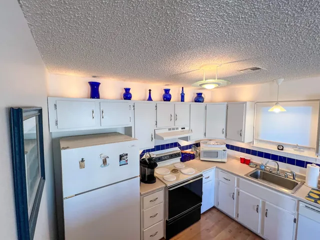 a kitchen that has a lot of cabinets in it and wooden floor