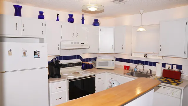 a kitchen with stainless steel appliances granite countertop a sink stove and white cabinets