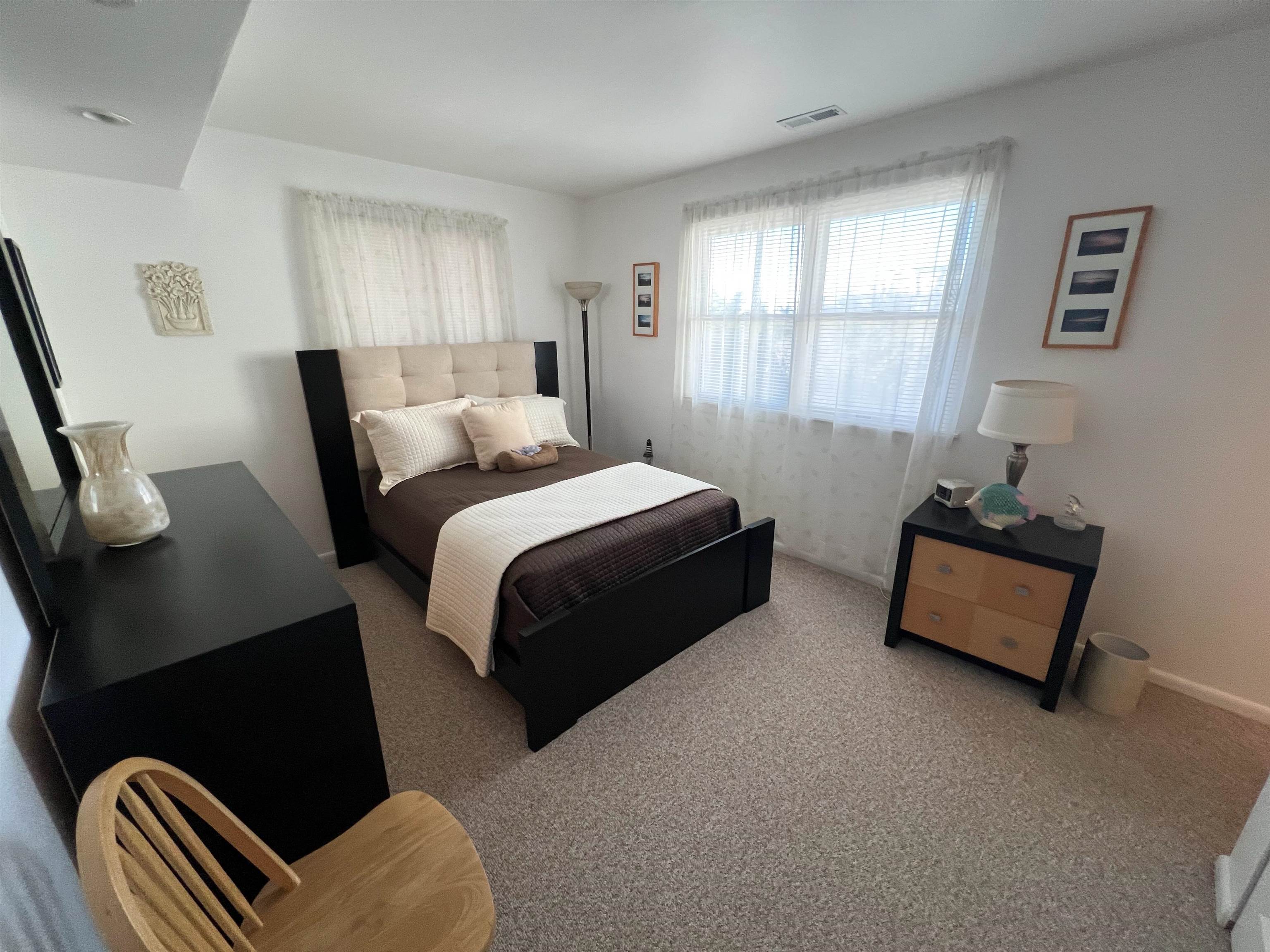 386 24th Street, Unit UPPR Avalon, NJ 08202 - Photo 10 of 34 a bedroom with bed lamp and a window