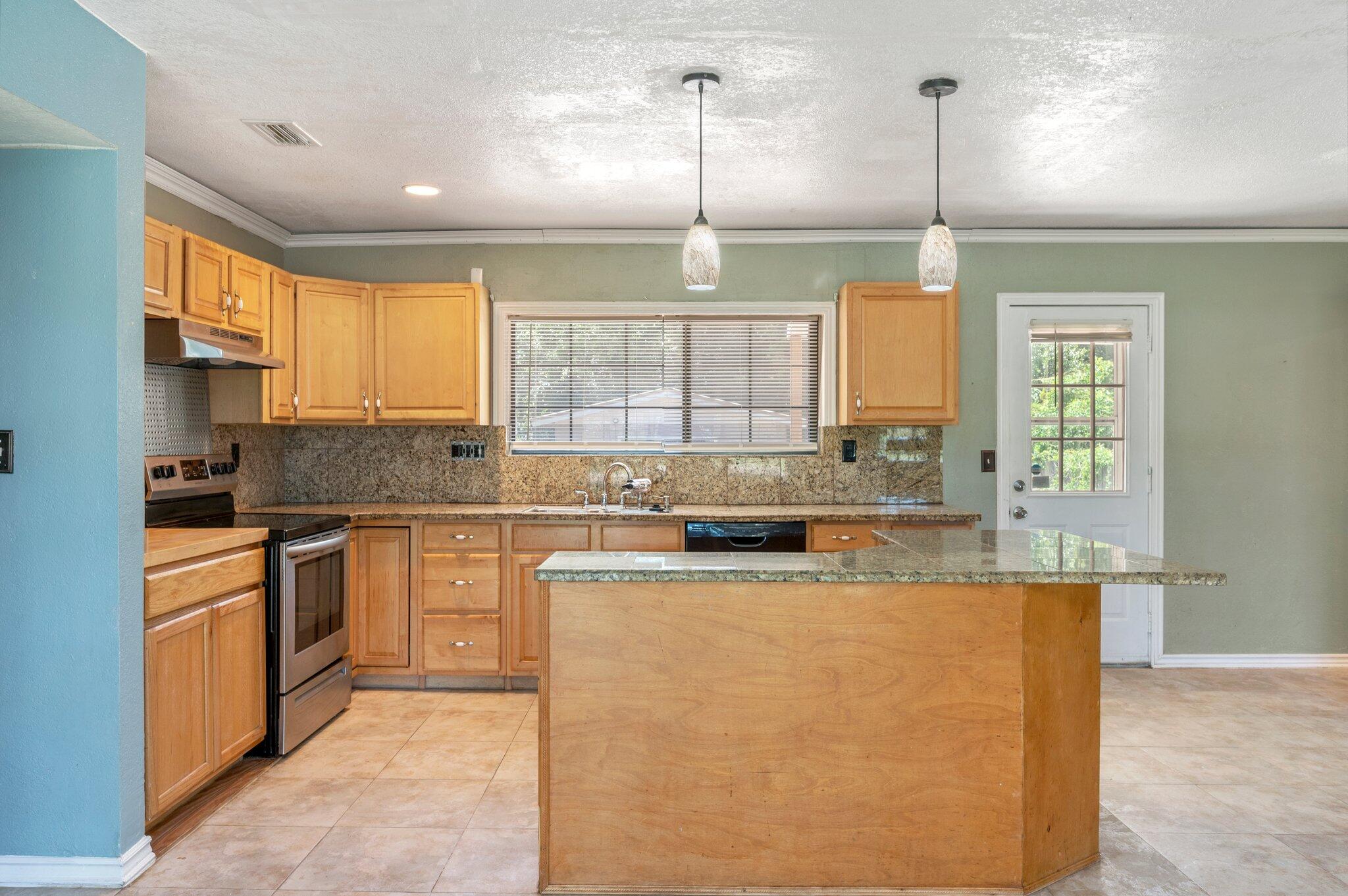 101 Seminole Trail Crestview, FL 32536 - Photo 11 of 30 a kitchen with kitchen island granite countertop white cabinets and window