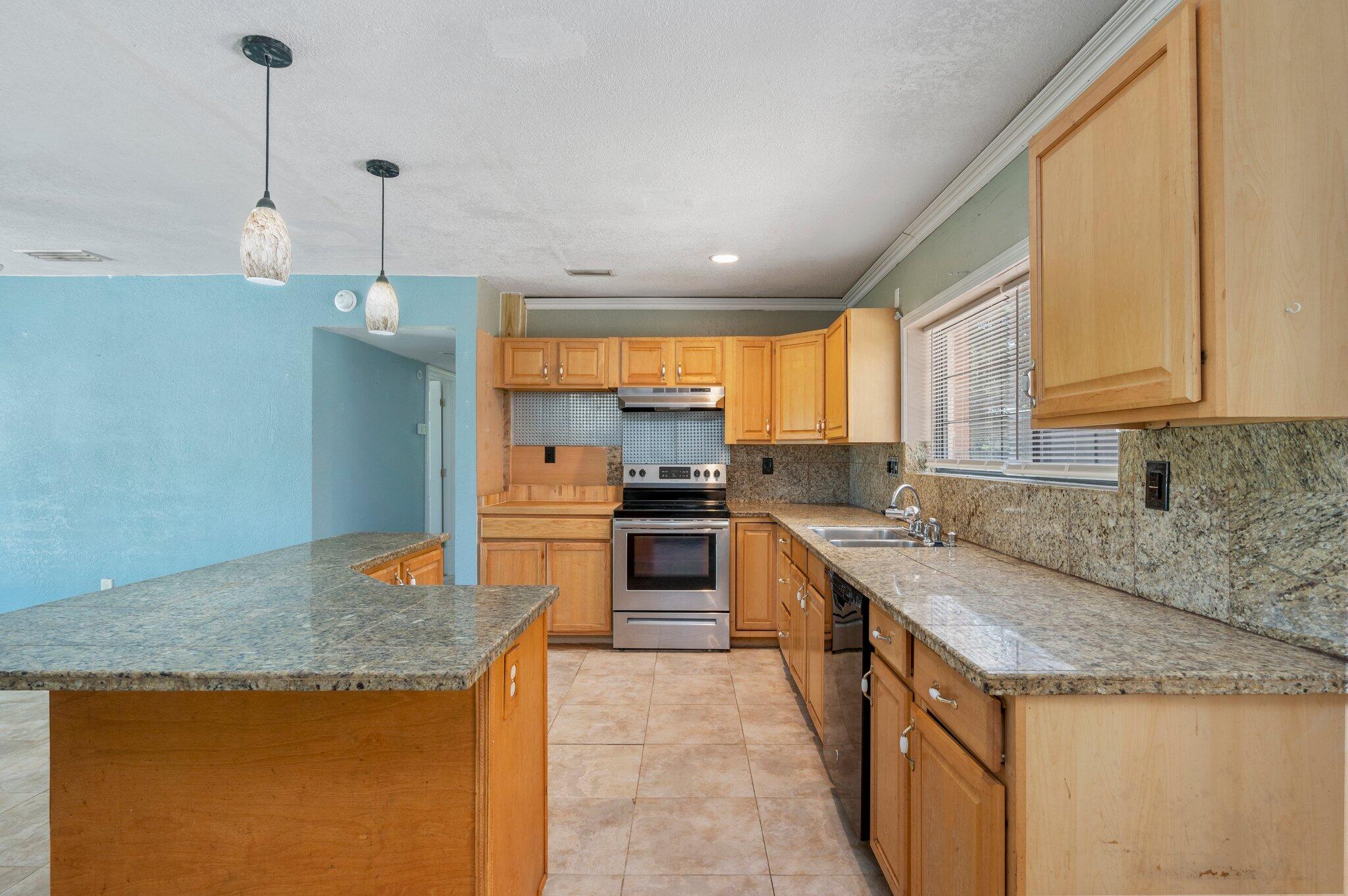 101 Seminole Trail Crestview, FL 32536 - Photo 12 of 30 a kitchen with stainless steel appliances granite countertop a sink a stove top oven a counter space and cabinets