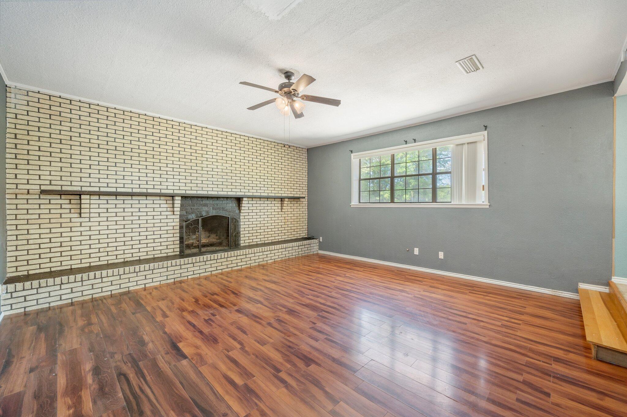 101 Seminole Trail Crestview, FL 32536 - Photo 8 of 30 a view of empty room with wooden floor and fireplace