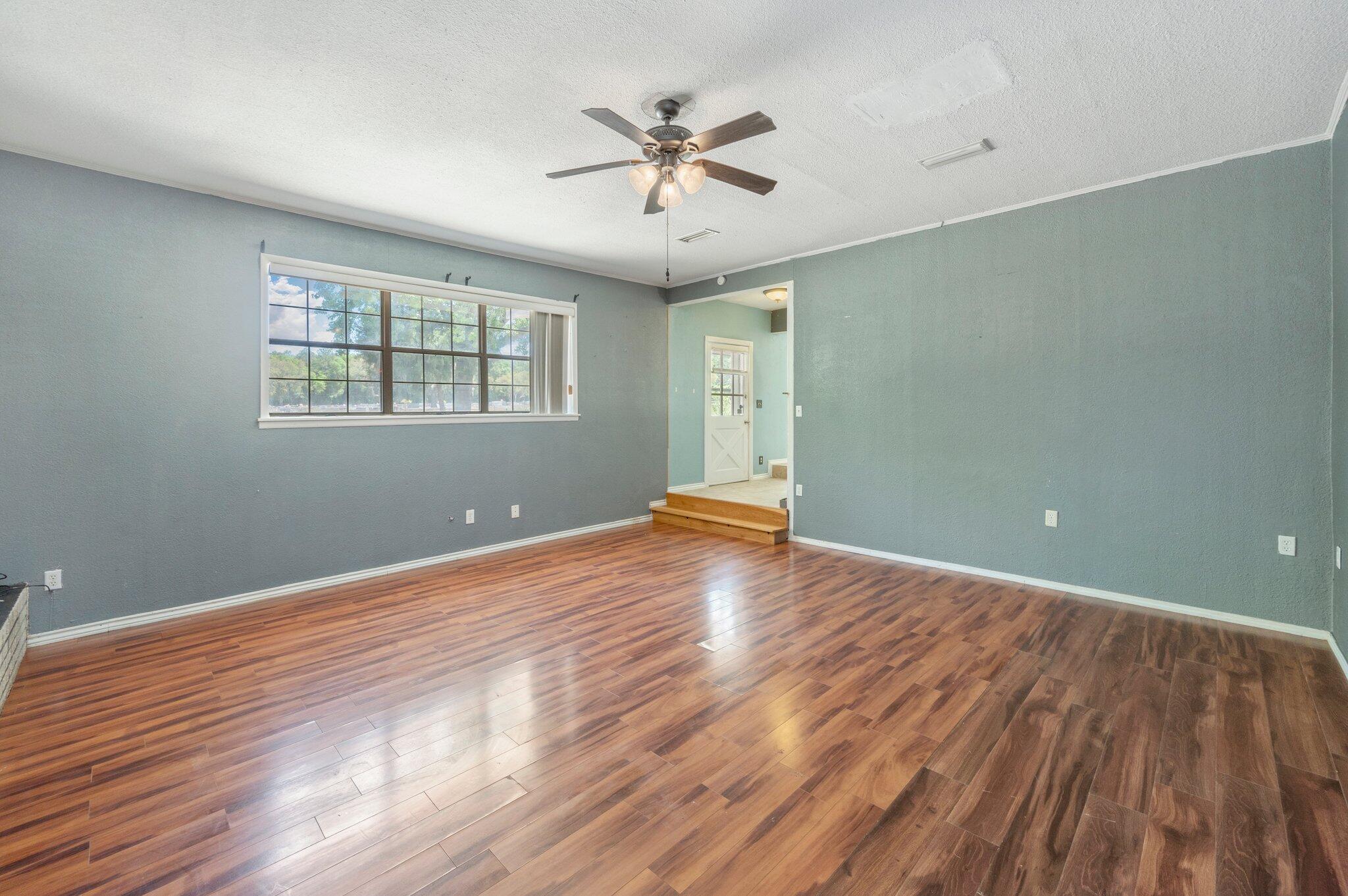 101 Seminole Trail Crestview, FL 32536 - Photo 9 of 30 an empty room with wooden floor and windows