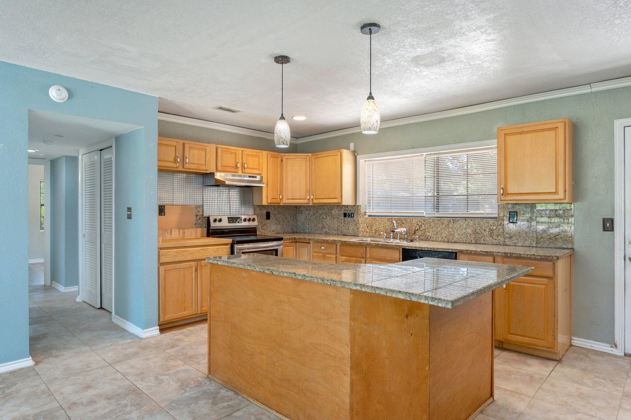 101 Seminole Trail Crestview, FL 32536 - Photo 10 of 30 a kitchen with stainless steel appliances granite countertop a sink a stove a refrigerator a center island and a window