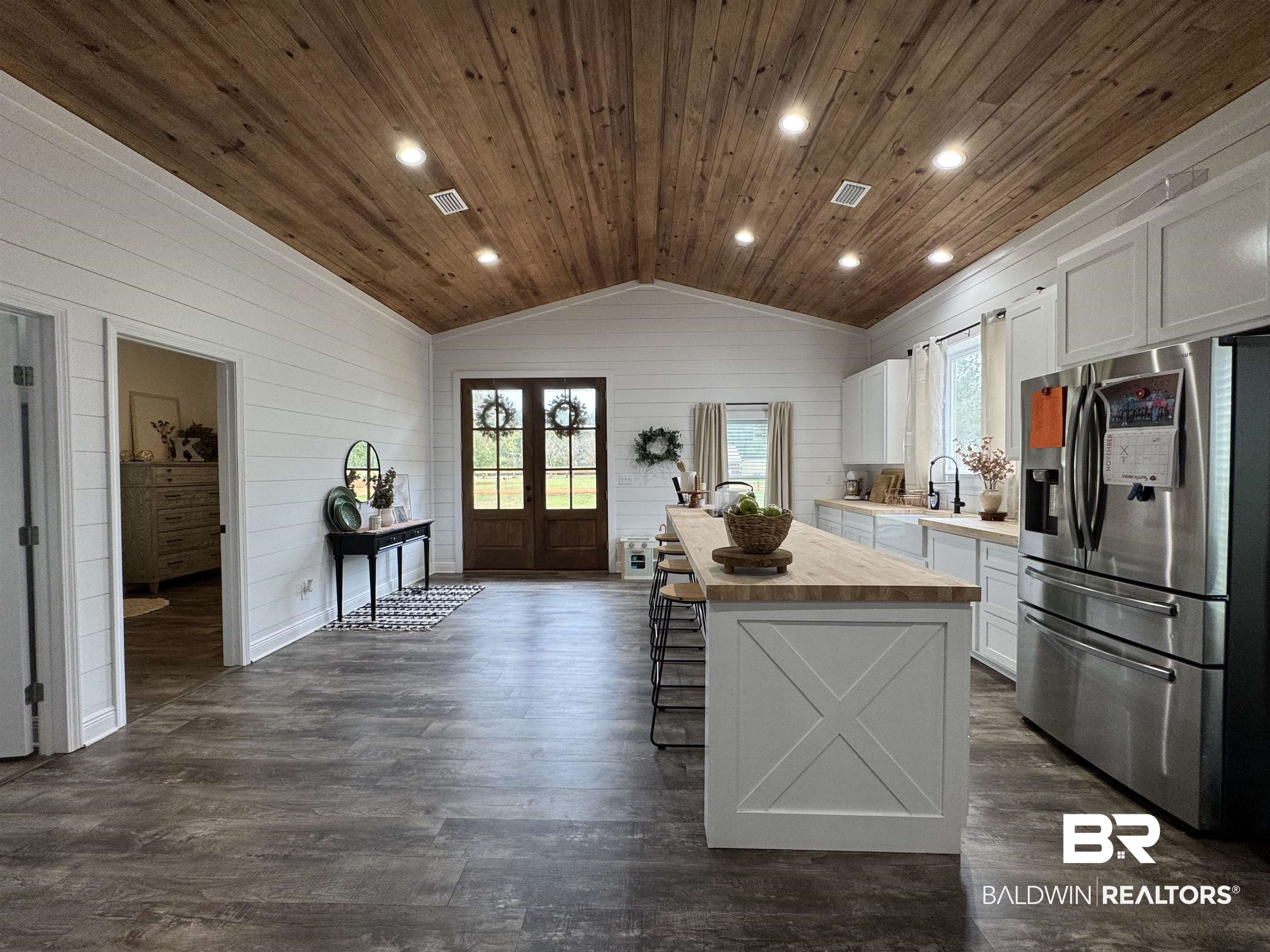 370 Dianne Road Frisco City, AL 36445 - Photo 6 of 41 Kitchen featuring wooden ceiling, white cabinetry, lofted ceiling, a center island, and stainless steel fridge