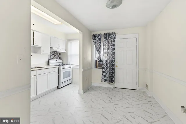 a kitchen with white cabinets and white appliances