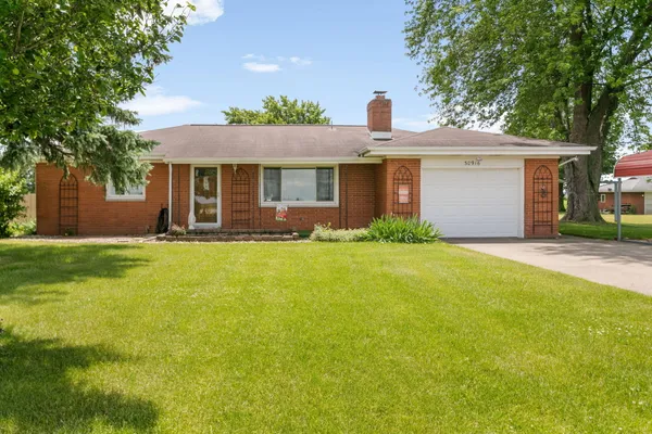 a front view of house with yard and trees around