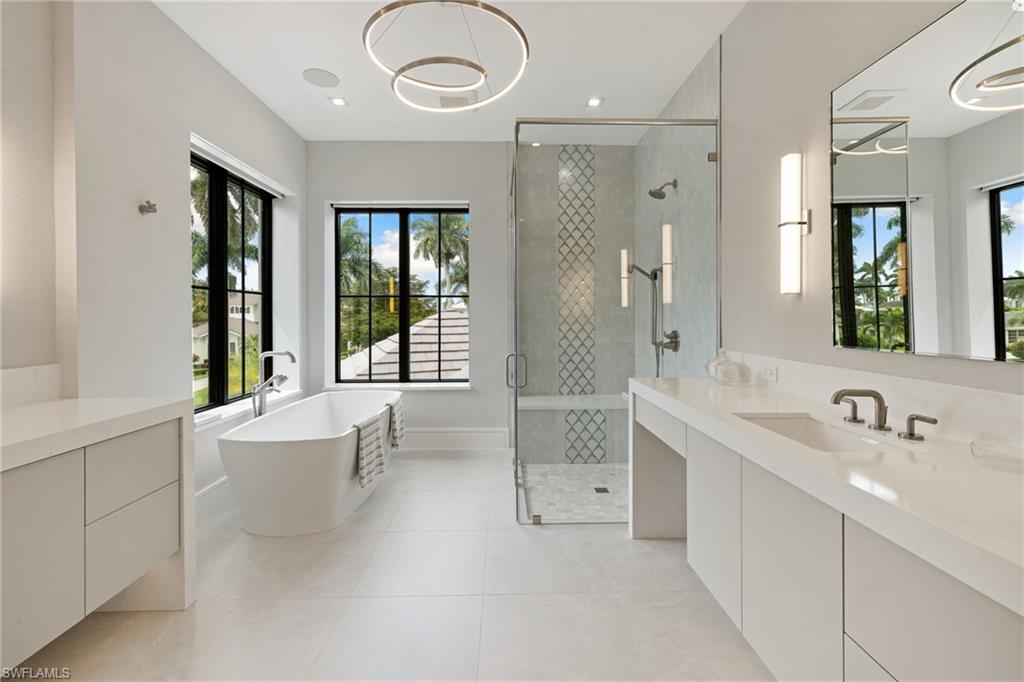 2345 Tarpon Road Naples, FL 34102 - Photo 31 of 43 Bathroom featuring a freestanding tub, a shower stall, vanity, and light tile patterned floors