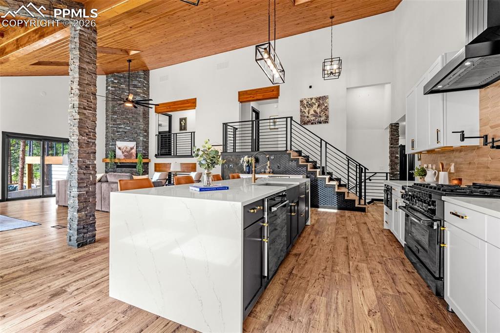 15520 Bar X Road Colorado Springs, CO 80908 - Photo 11 of 50 a kitchen view with stainless steel appliances kitchen island granite countertop a stove and a wooden floors