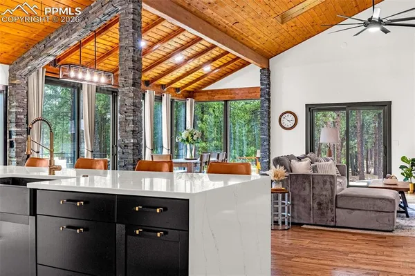 a kitchen with stainless steel appliances granite countertop a stove a sink dishwasher and white cabinets with wooden floor