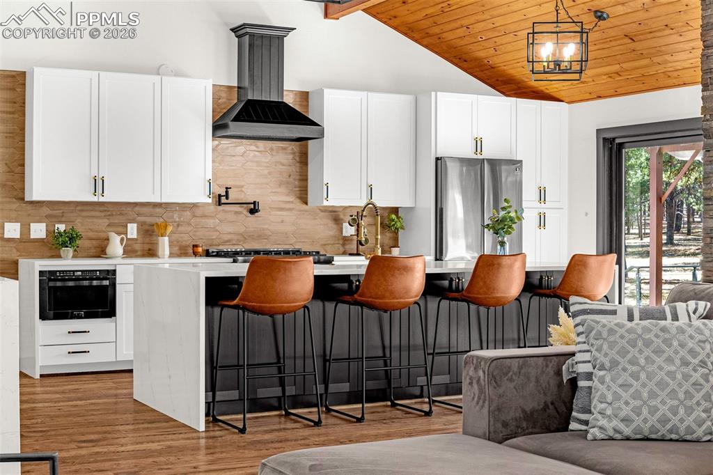 15520 Bar X Road Colorado Springs, CO 80908 - Photo 19 of 50 a kitchen with stainless steel appliances granite countertop a stove a sink dishwasher and white cabinets with wooden floor