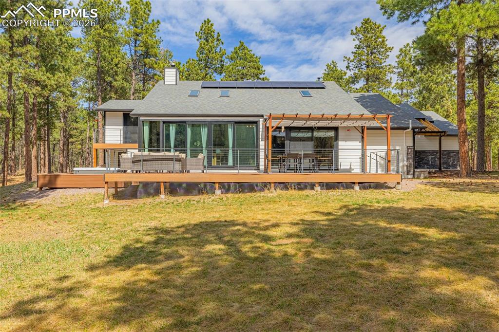 15520 Bar X Road Colorado Springs, CO 80908 - Photo 39 of 50 a front view of a house with a yard table and chairs