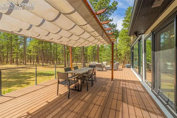 a view of a patio with couches and table and chairs next to a yard
