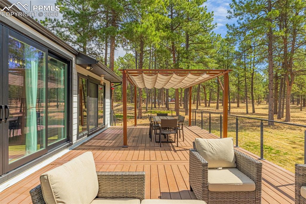 15520 Bar X Road Colorado Springs, CO 80908 - Photo 42 of 50 a view of a patio with couches and table and chairs next to a yard