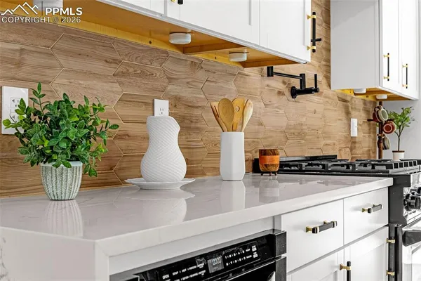 a kitchen with stainless steel appliances granite countertop a refrigerator a stove a sink and chairs
