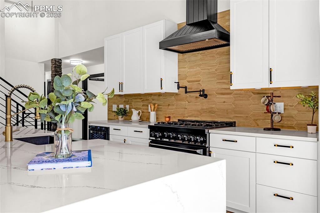 15520 Bar X Road Colorado Springs, CO 80908 - Photo 10 of 50 a kitchen with stainless steel appliances kitchen island granite countertop a stove a sink and white cabinets