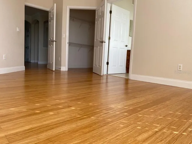 an empty room with wooden floor and shower