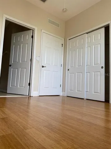 a view of empty room with wooden floor