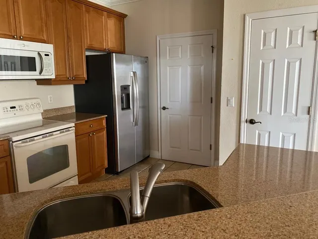 a kitchen with a sink a refrigerator and cabinets