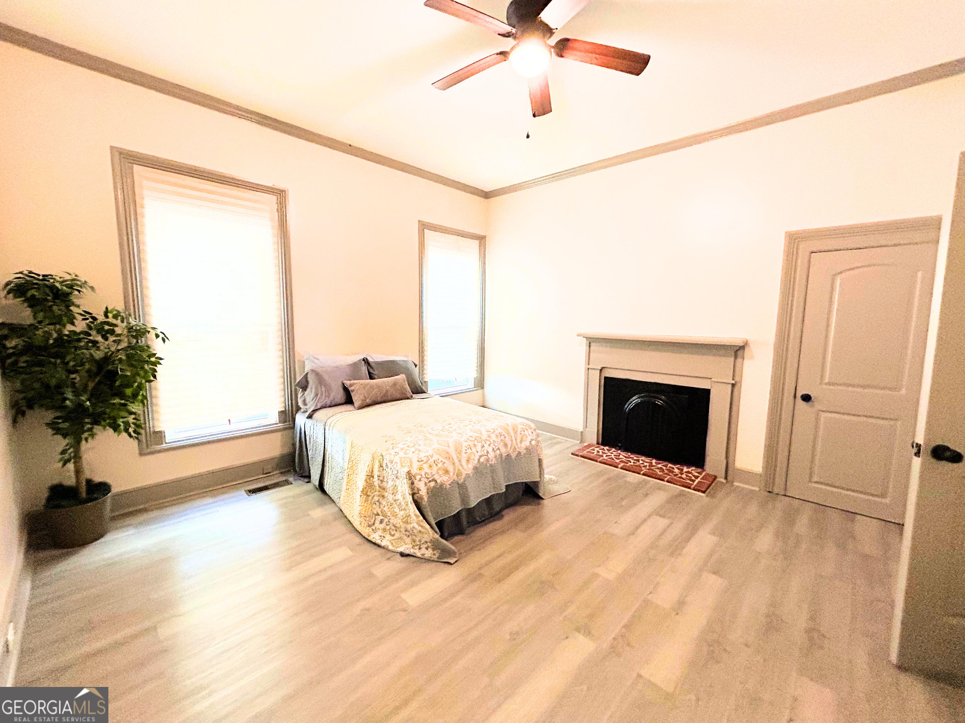 518 East Furlow Street Americus, GA 31709 - Photo 11 of 28 a spacious bedroom with a bed and a chandelier