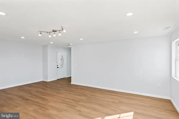 a kitchen with stainless steel appliances granite countertop white cabinets a sink a stove a microwave and wooden floors