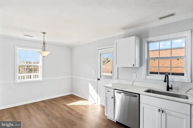 a kitchen with stainless steel appliances white cabinets and a refrigerator