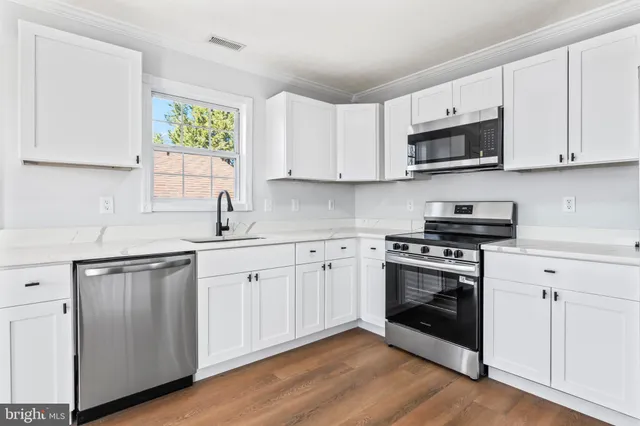 a view of a livingroom with wooden floor and a large window