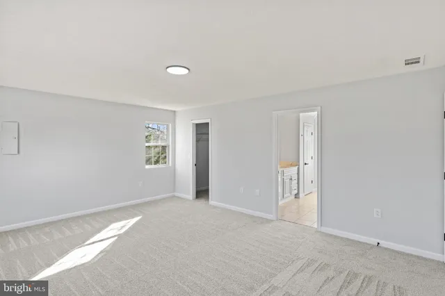a view of an empty room with wooden floor and closet
