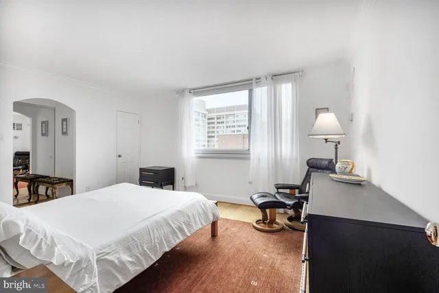 a bedroom with a bed a dresser and a couch