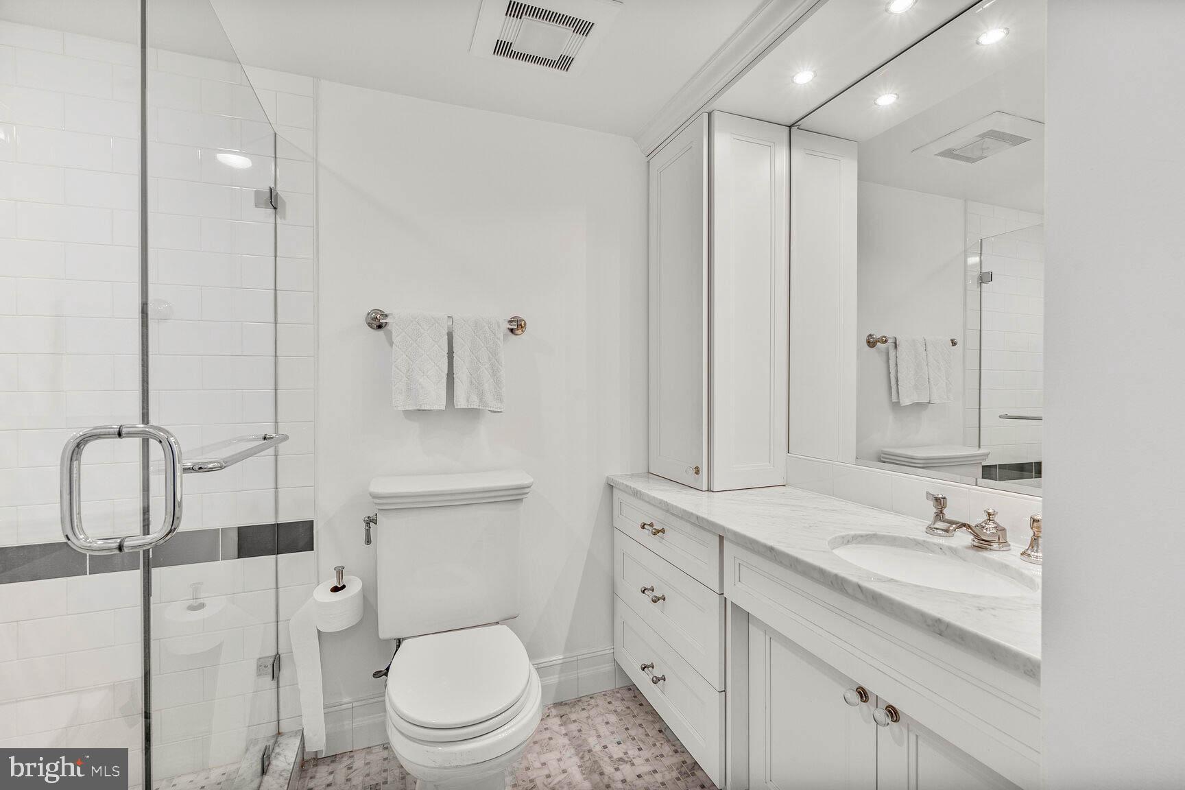 4601 North Park Avenue, Unit 1118 Chevy Chase, MD 20815 - Photo 17 of 30 a bathroom with a toilet sink and shower