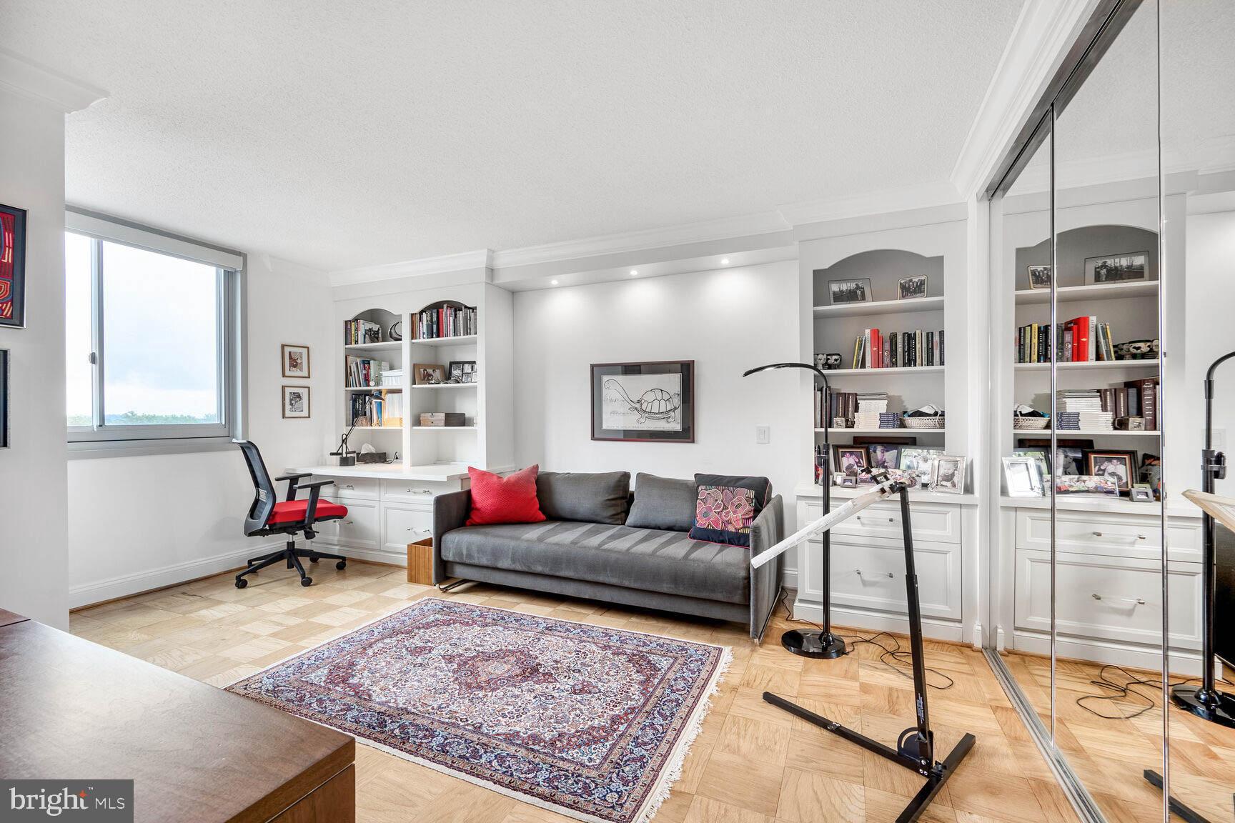 4601 North Park Avenue, Unit 1118 Chevy Chase, MD 20815 - Photo 19 of 30 a living room with furniture and a book shelf
