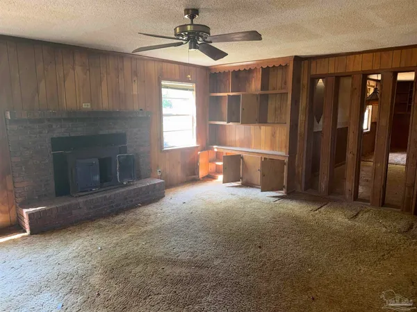 a view of empty room with a fireplace and window