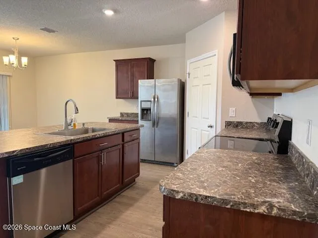 a kitchen with stainless steel appliances granite countertop a sink refrigerator and cabinets