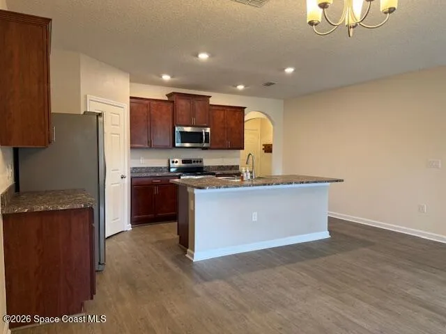 a kitchen with stainless steel appliances granite countertop a stove a sink and a refrigerator